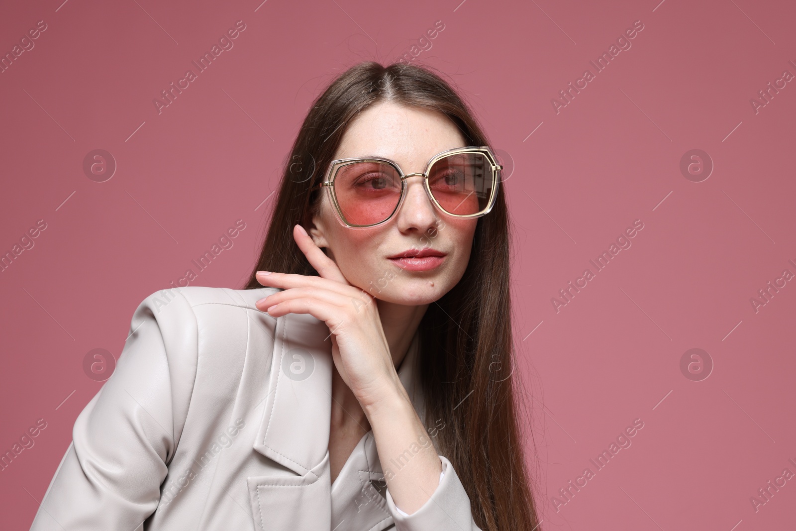 Fashionable portrait of beautiful woman in stylish outfit on pink background Photo of Fashionable portrait of beautiful woman in stylish outfit on pink background