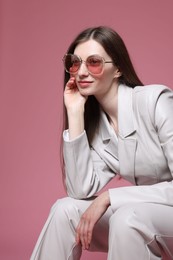Photo of Fashionable portrait of beautiful woman in stylish outfit on pink background