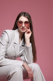 Photo of Fashionable portrait of beautiful woman in stylish outfit on pink background