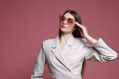 Photo of Fashionable portrait of beautiful woman in stylish outfit on pink background