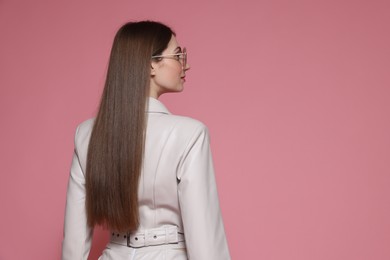 Photo of Woman in stylish outfit on pink background. Space for text