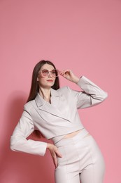 Photo of Fashionable portrait of beautiful woman in stylish outfit on pink background