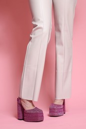 Photo of Woman in stylish outfit on pink background, closeup