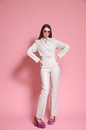 Photo of Fashionable full-length portrait of beautiful woman in stylish outfit on pink background