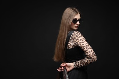 Photo of Fashionable portrait of beautiful woman in stylish outfit on black background. Space for text