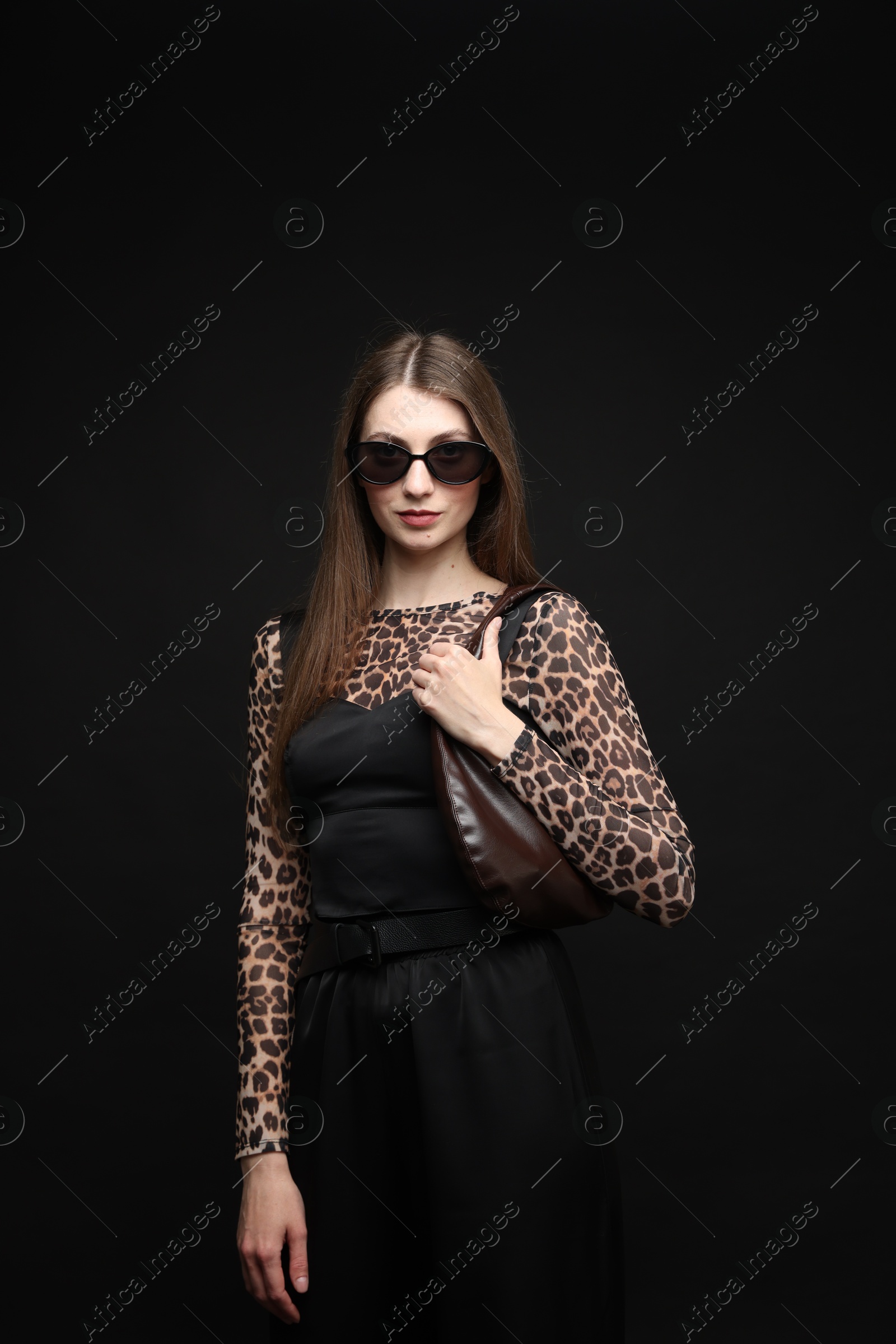Fashionable portrait of beautiful woman in stylish outfit on black background Photo of Fashionable portrait of beautiful woman in stylish outfit on black background
