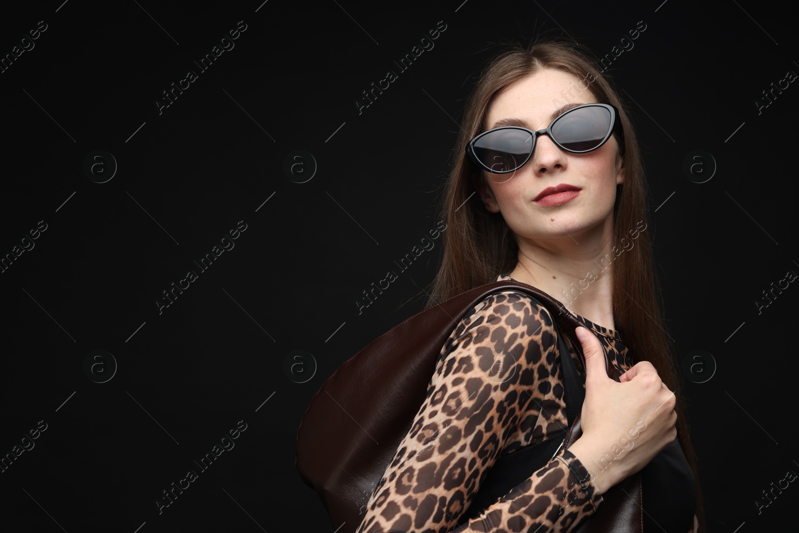 Fashionable portrait of beautiful woman in stylish outfit on black background. Space for text Photo of Fashionable portrait of beautiful woman in stylish outfit on black background. Space for text