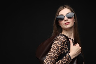 Photo of Fashionable portrait of beautiful woman in stylish outfit on black background. Space for text
