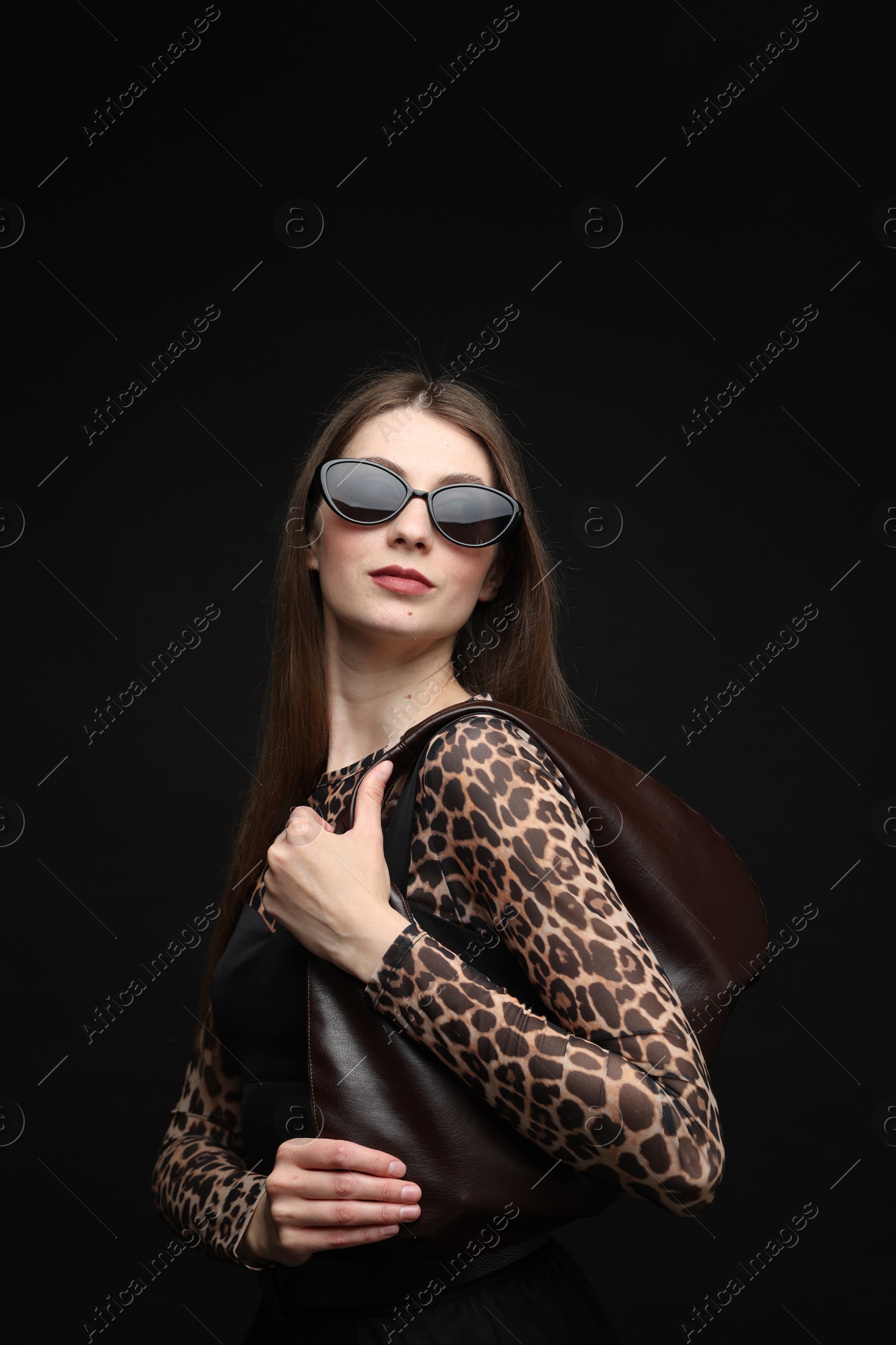 Fashionable portrait of beautiful woman in stylish outfit on black background Photo of Fashionable portrait of beautiful woman in stylish outfit on black background