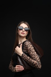 Photo of Fashionable portrait of beautiful woman in stylish outfit on black background