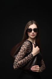 Photo of Fashionable portrait of beautiful woman in stylish outfit on black background