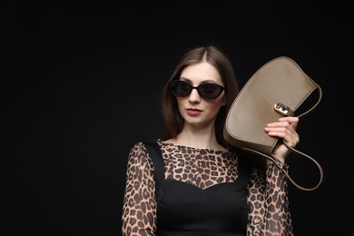 Photo of Fashionable portrait of beautiful woman in stylish outfit on black background. Space for text