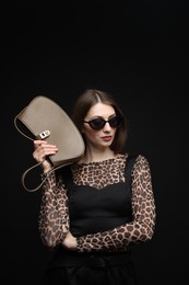 Photo of Fashionable portrait of beautiful woman in stylish outfit on black background