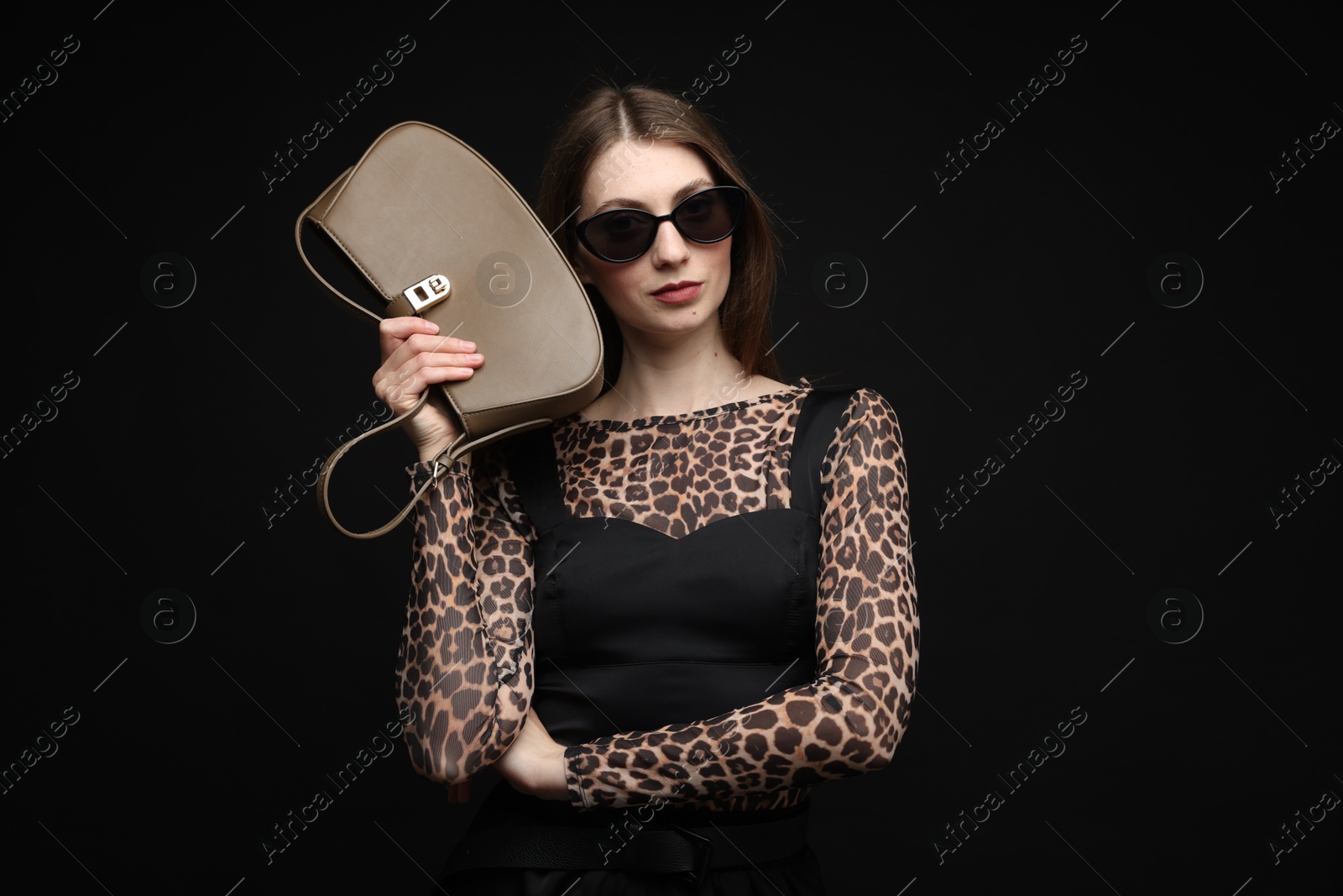 Fashionable portrait of beautiful woman in stylish outfit on black background Photo of Fashionable portrait of beautiful woman in stylish outfit on black background