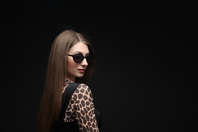 Photo of Fashionable portrait of beautiful woman in stylish outfit on black background. Space for text