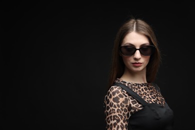Photo of Fashionable portrait of beautiful woman in stylish outfit on black background. Space for text