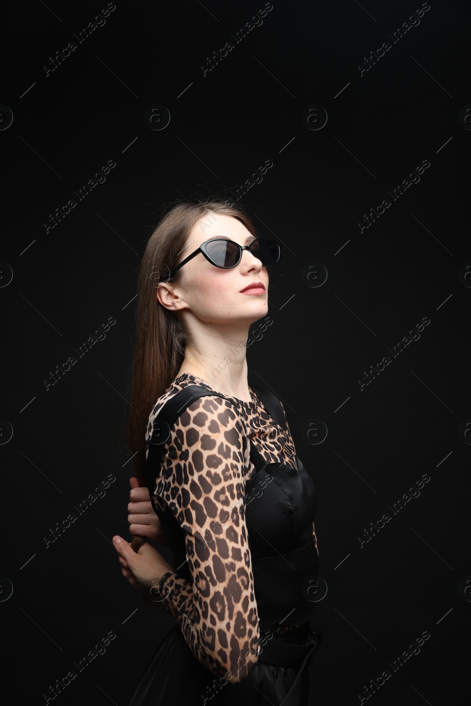 Fashionable portrait of beautiful woman in stylish outfit on black background Photo of Fashionable portrait of beautiful woman in stylish outfit on black background