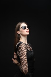 Photo of Fashionable portrait of beautiful woman in stylish outfit on black background