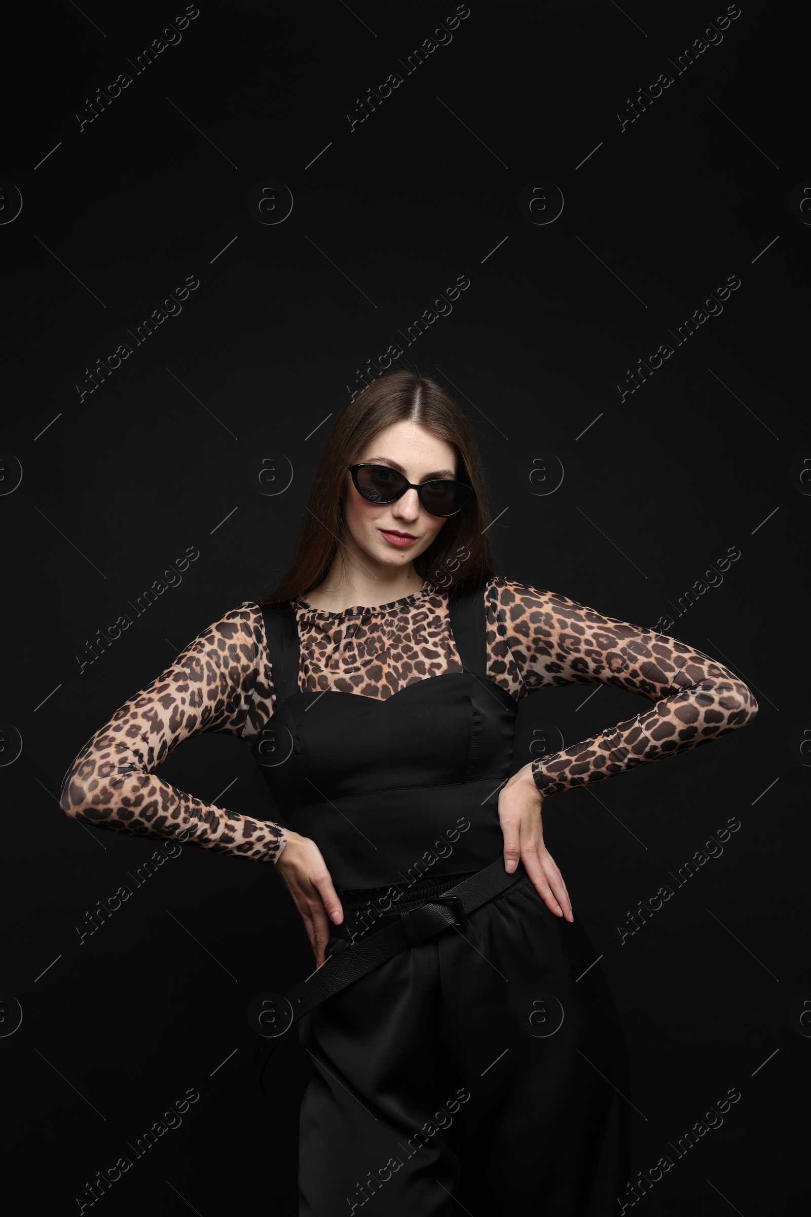 Fashionable portrait of beautiful woman in stylish outfit on black background Photo of Fashionable portrait of beautiful woman in stylish outfit on black background