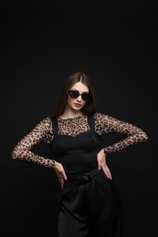 Photo of Fashionable portrait of beautiful woman in stylish outfit on black background