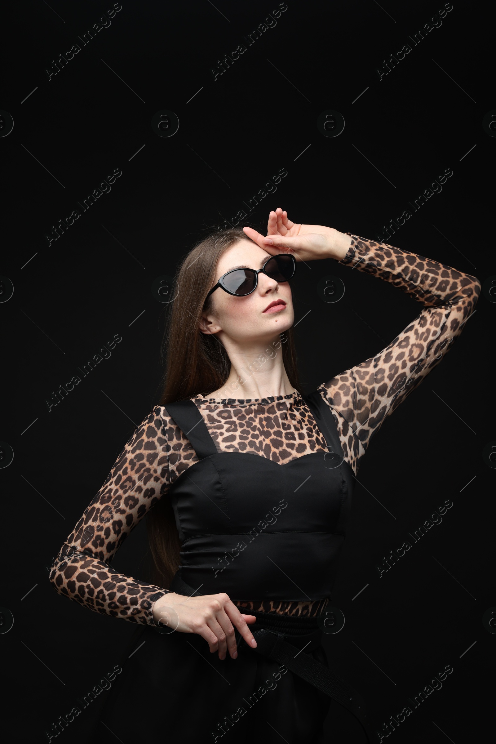 Fashionable portrait of beautiful woman in stylish outfit on black background Photo of Fashionable portrait of beautiful woman in stylish outfit on black background