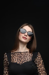 Photo of Fashionable portrait of beautiful woman in stylish outfit on black background