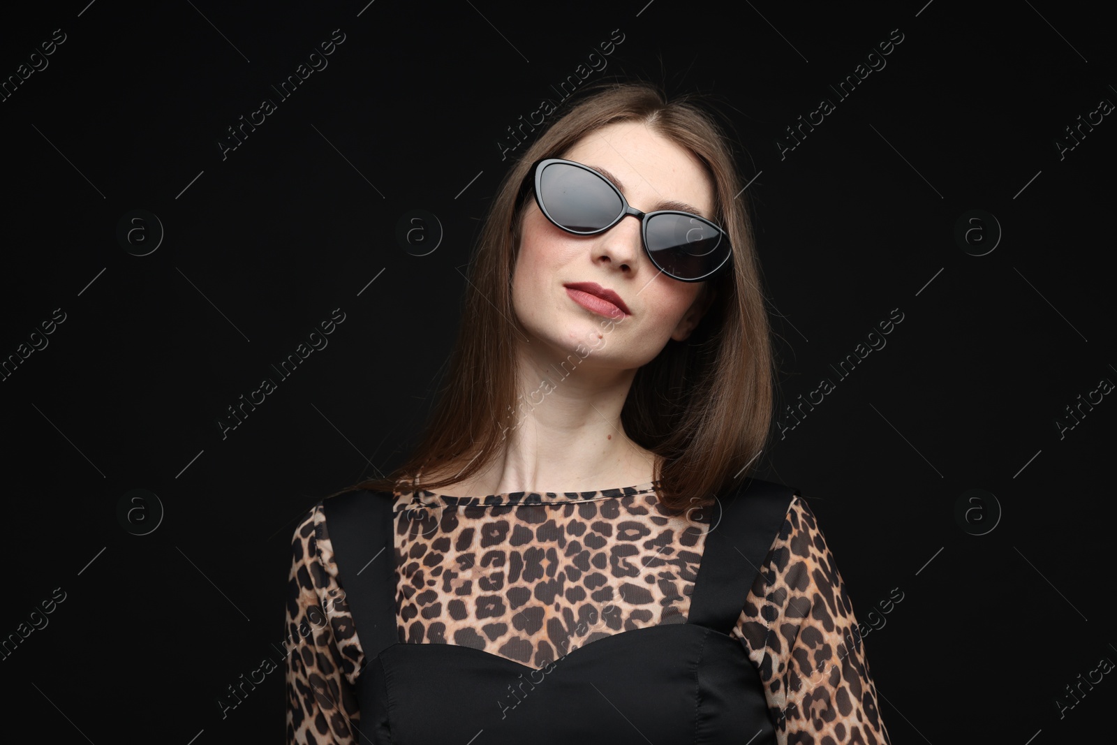 Fashionable portrait of beautiful woman in stylish outfit on black background Photo of Fashionable portrait of beautiful woman in stylish outfit on black background