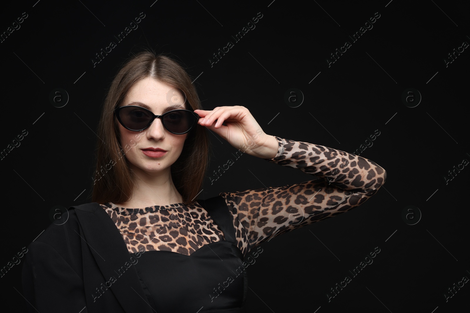 Fashionable portrait of beautiful woman in stylish outfit on black background Photo of Fashionable portrait of beautiful woman in stylish outfit on black background