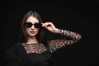 Photo of Fashionable portrait of beautiful woman in stylish outfit on black background