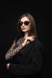 Photo of Fashionable portrait of beautiful woman in stylish outfit on black background