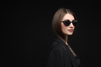 Photo of Fashionable portrait of beautiful woman in stylish outfit on black background. Space for text