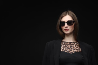 Photo of Fashionable portrait of beautiful woman in stylish outfit on black background. Space for text