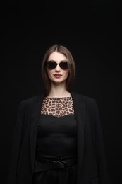 Photo of Fashionable portrait of beautiful woman in stylish outfit on black background