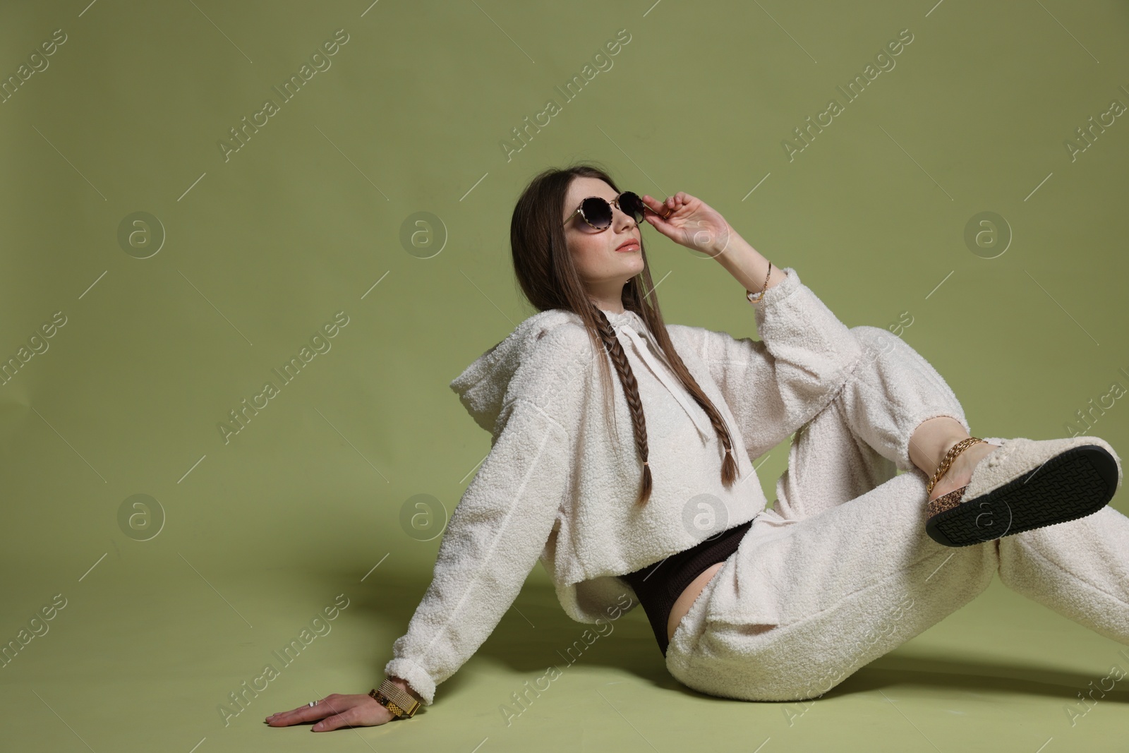 Fashionable portrait of beautiful woman in stylish outfit on green background Photo of Fashionable portrait of beautiful woman in stylish outfit on green background