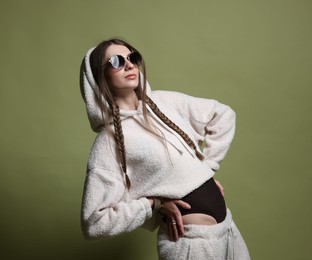 Photo of Fashionable portrait of beautiful woman in stylish outfit on green background