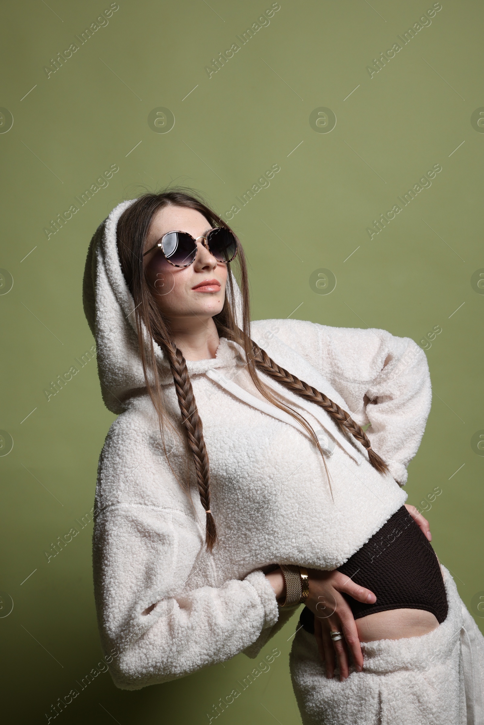 Fashionable portrait of beautiful woman in stylish outfit on green background Photo of Fashionable portrait of beautiful woman in stylish outfit on green background