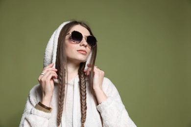 Photo of Fashionable portrait of beautiful woman in stylish outfit on green background. Space for text