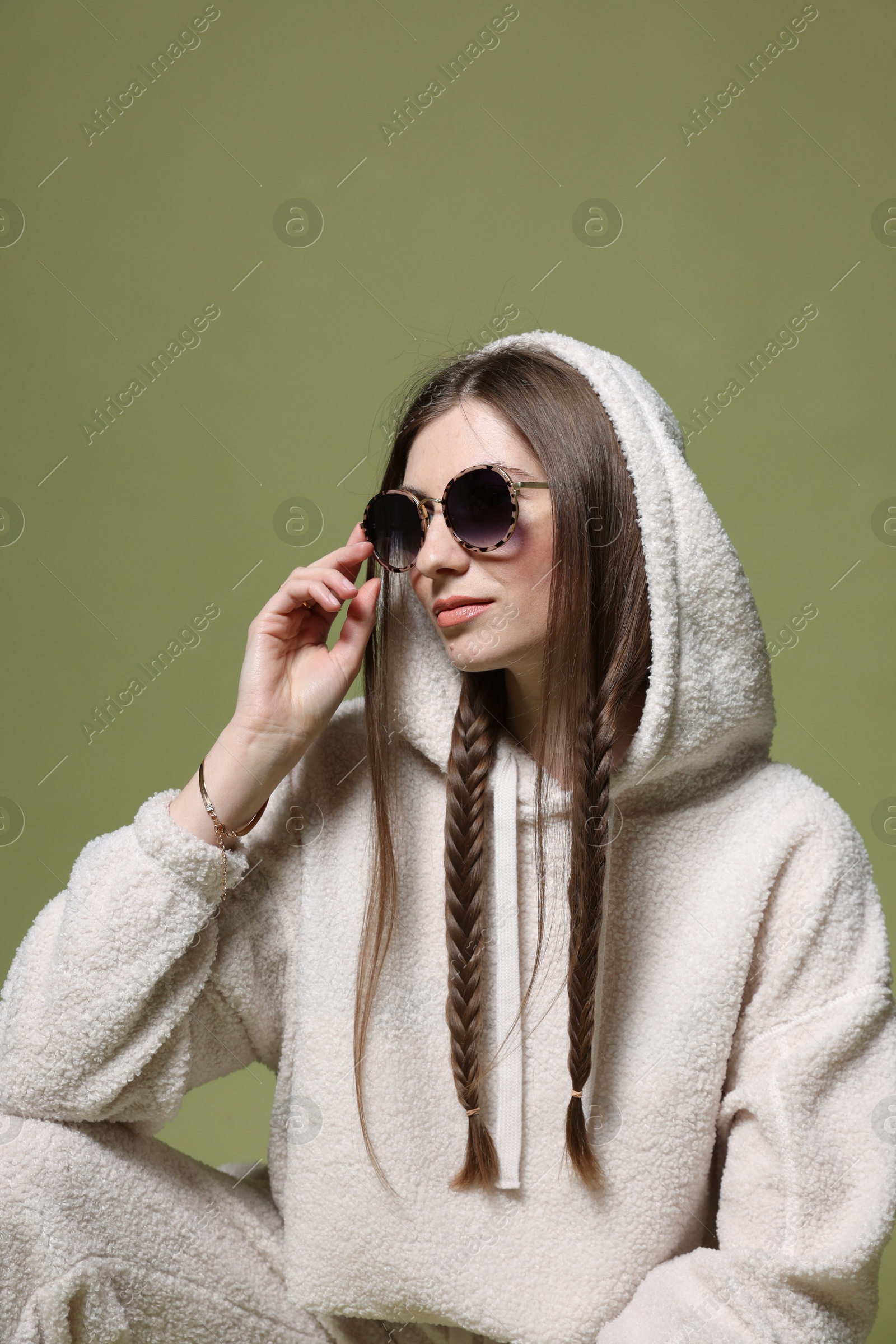 Fashionable portrait of beautiful woman in stylish outfit on green background Photo of Fashionable portrait of beautiful woman in stylish outfit on green background