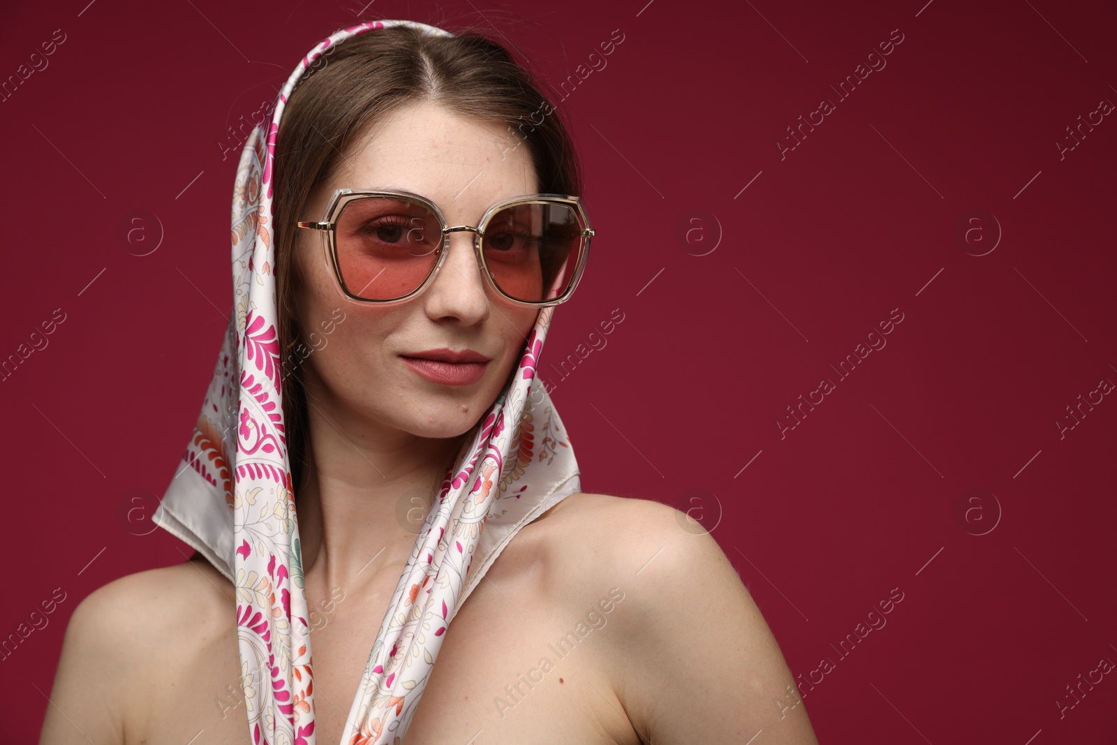 Fashionable portrait of beautiful woman in stylish outfit on dark red background. Space for text Photo of Fashionable portrait of beautiful woman in stylish outfit on dark red background. Space for text