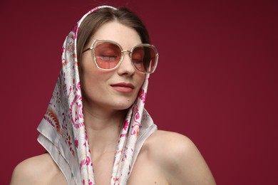 Photo of Fashionable portrait of beautiful woman in stylish outfit on dark red background. Space for text