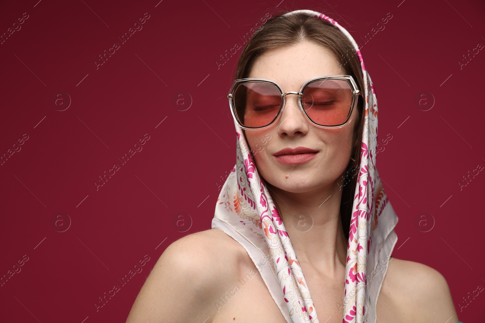 Fashionable portrait of beautiful woman in stylish outfit on dark red background. Space for text Photo of Fashionable portrait of beautiful woman in stylish outfit on dark red background. Space for text