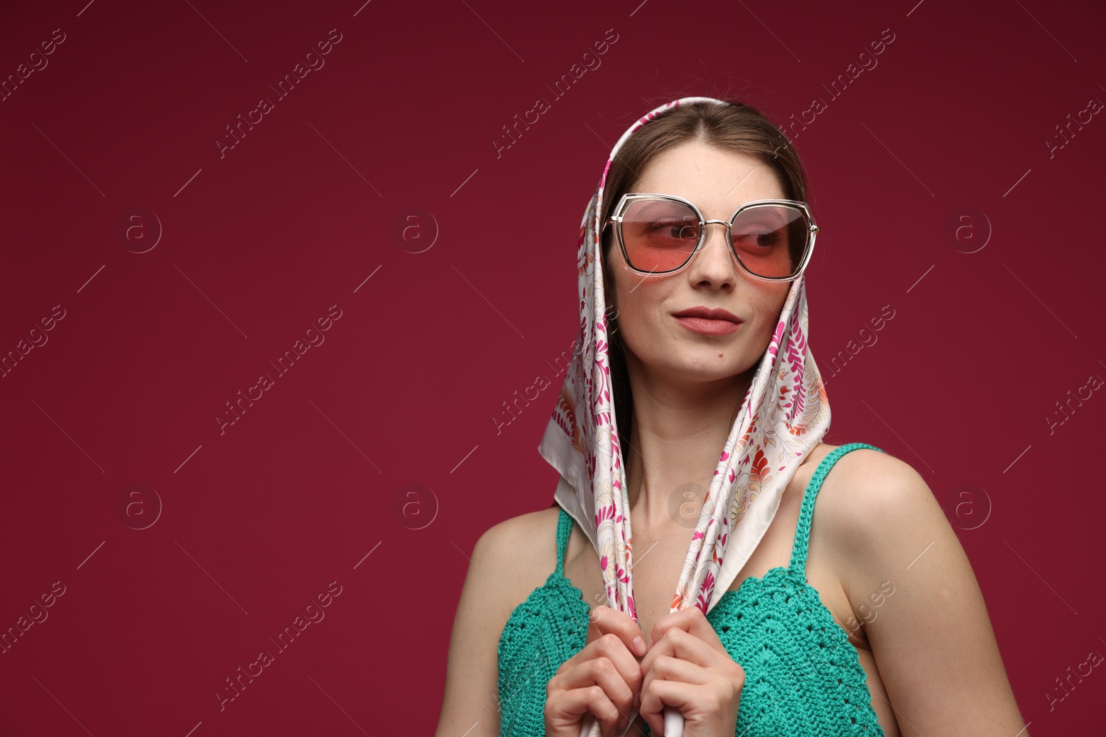 Fashionable portrait of beautiful woman in stylish outfit on dark red background. Space for text Photo of Fashionable portrait of beautiful woman in stylish outfit on dark red background. Space for text