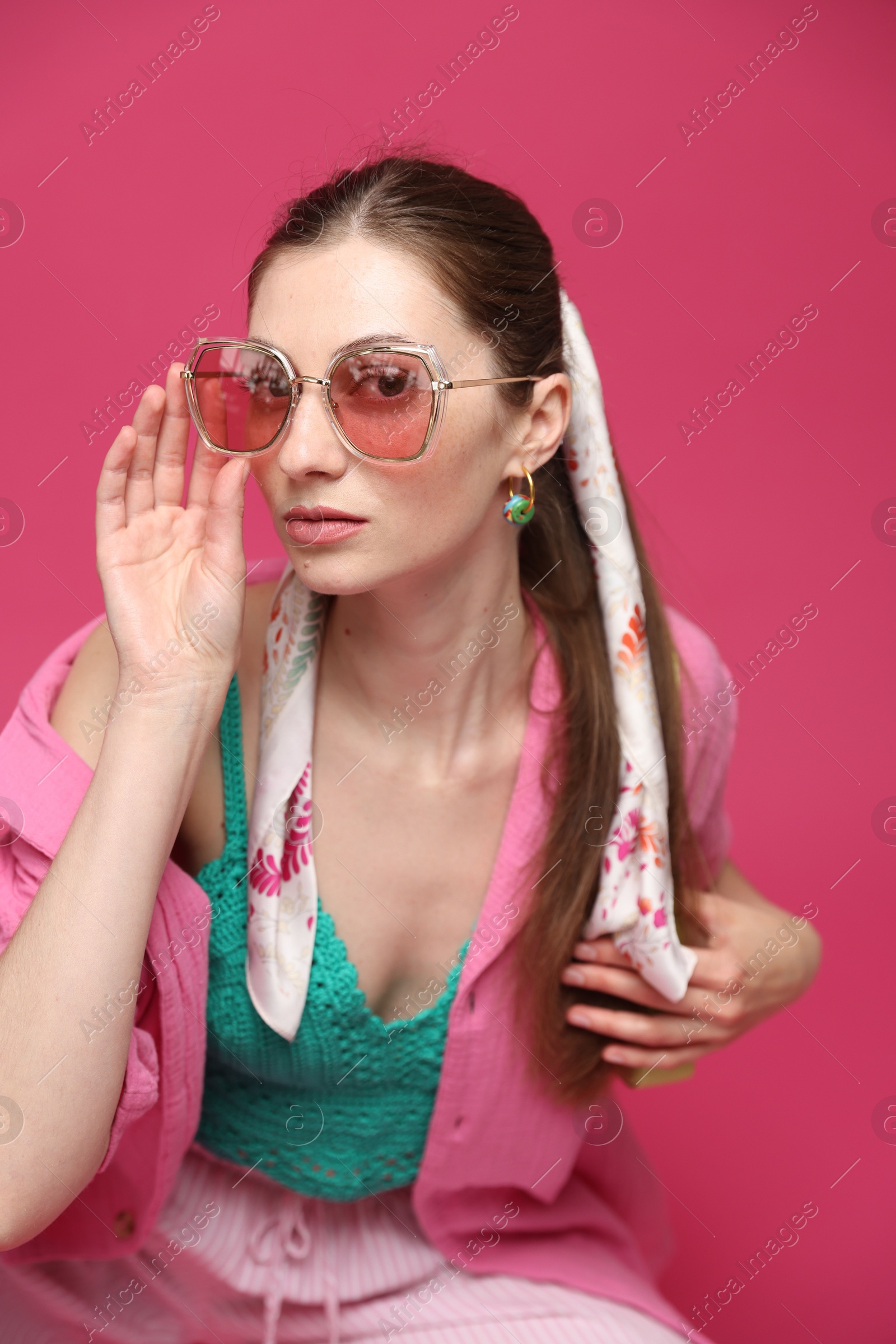 Fashionable portrait of beautiful woman in stylish outfit on pink background Photo of Fashionable portrait of beautiful woman in stylish outfit on pink background