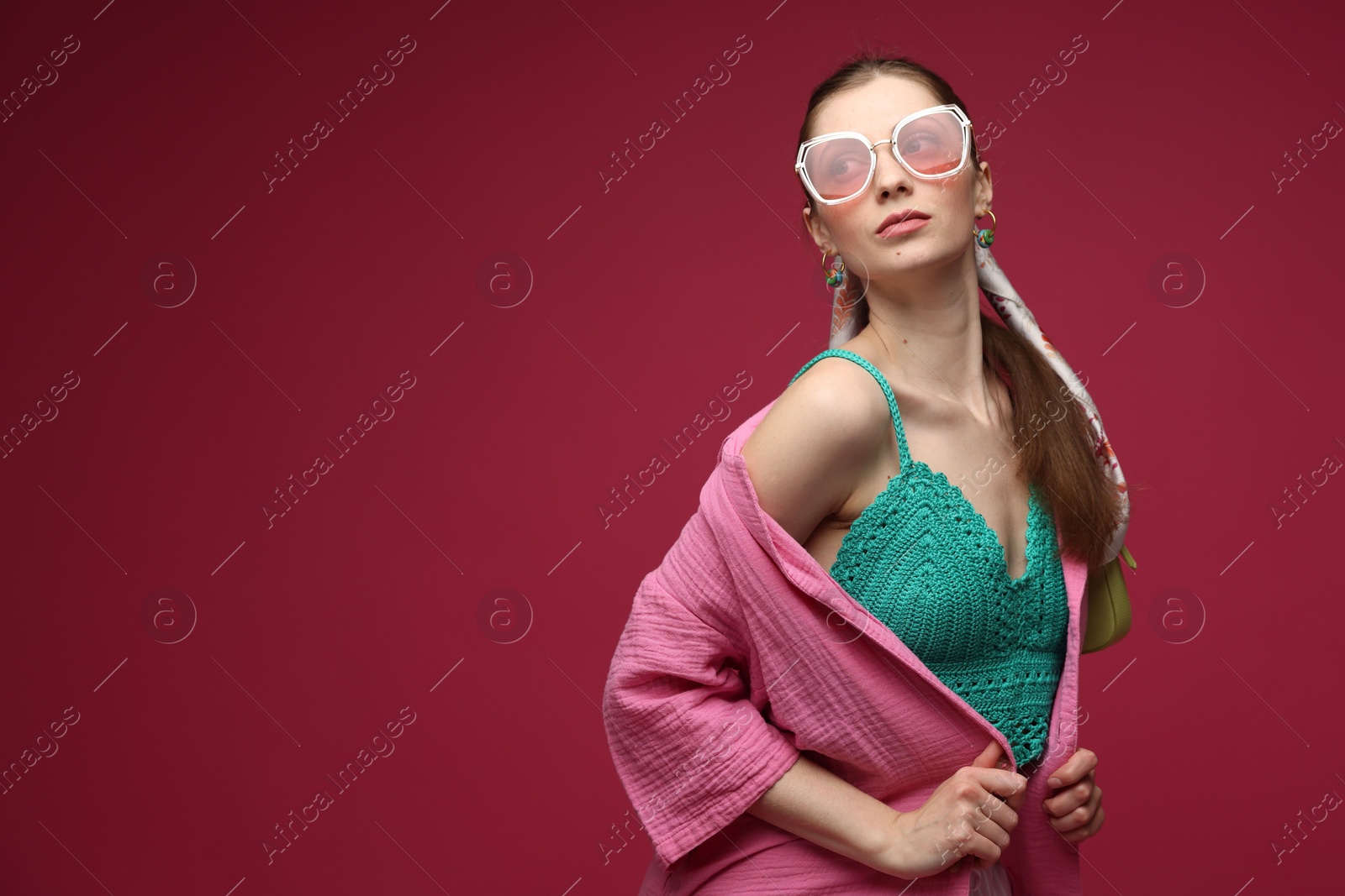 Fashionable portrait of beautiful woman in stylish outfit on dark red background. Space for text Photo of Fashionable portrait of beautiful woman in stylish outfit on dark red background. Space for text