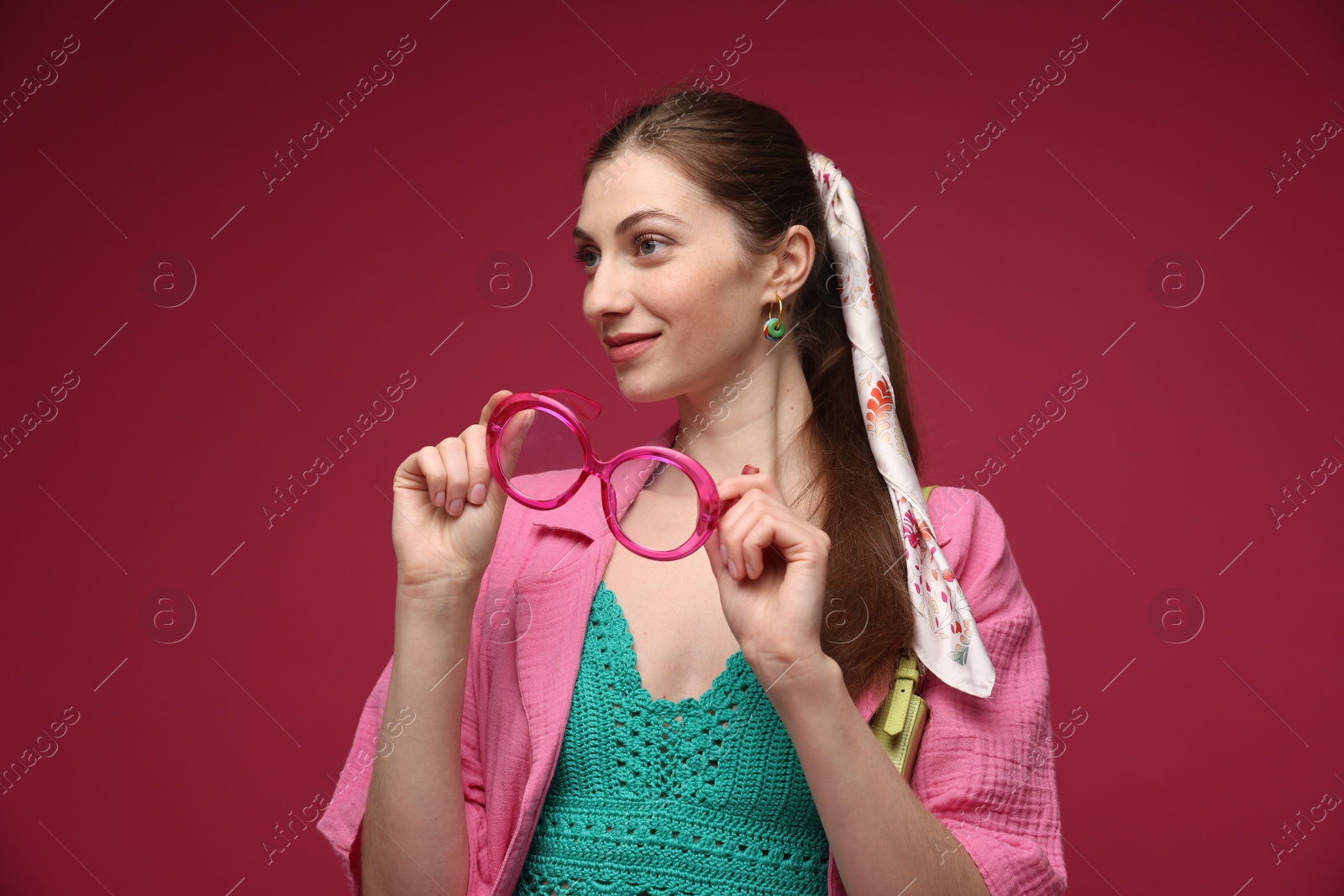 Fashionable portrait of beautiful woman in stylish outfit on dark red background Photo of Fashionable portrait of beautiful woman in stylish outfit on dark red background
