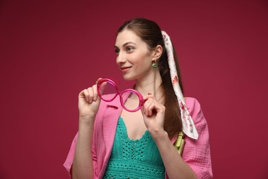 Photo of Fashionable portrait of beautiful woman in stylish outfit on dark red background