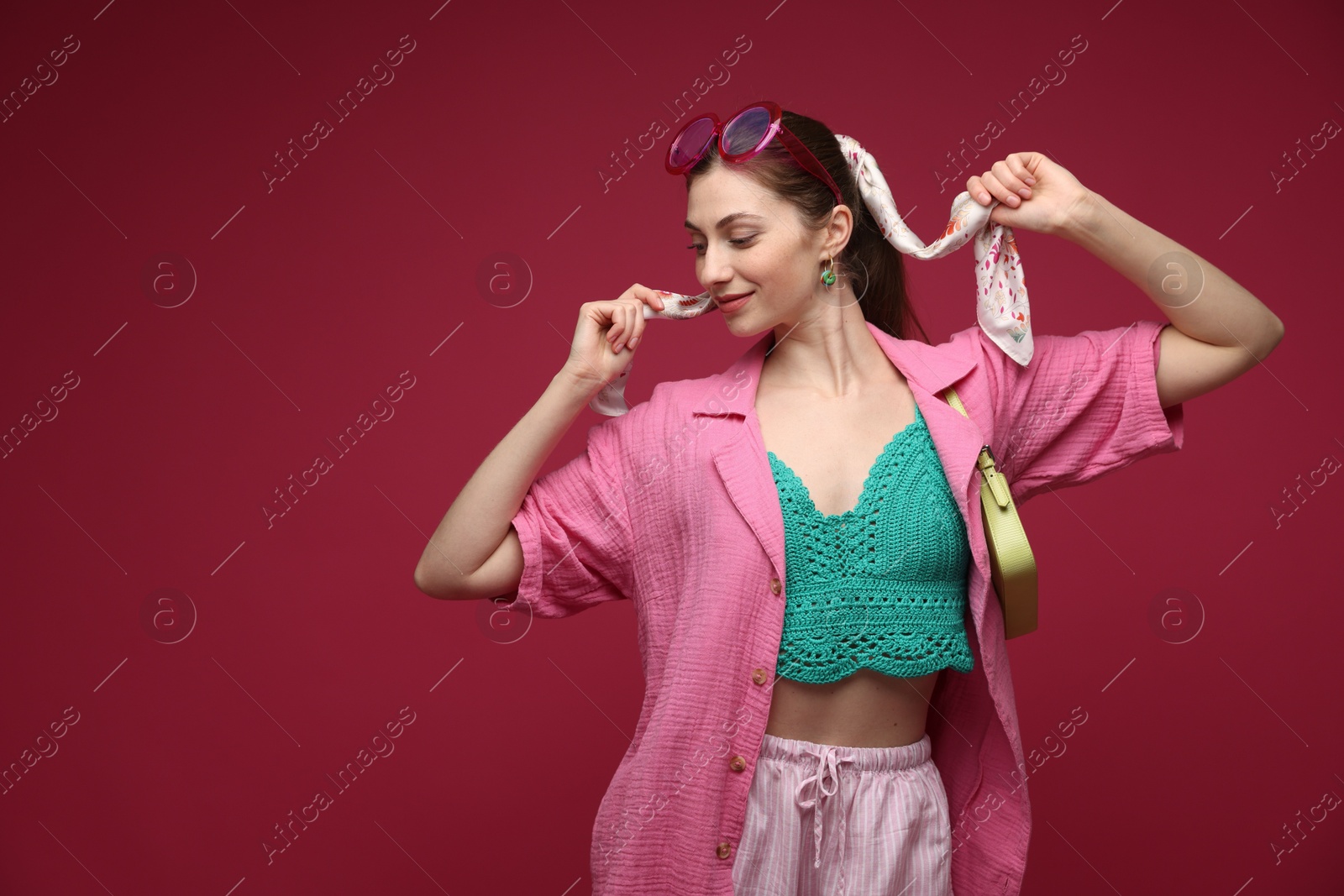 Fashionable portrait of beautiful woman in stylish outfit on dark red background. Space for text Photo of Fashionable portrait of beautiful woman in stylish outfit on dark red background. Space for text