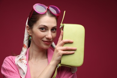 Photo of Fashionable portrait of beautiful woman in stylish outfit on dark red background