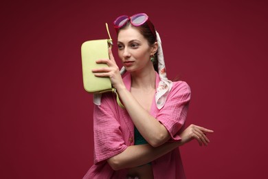 Photo of Fashionable portrait of beautiful woman in stylish outfit on dark red background