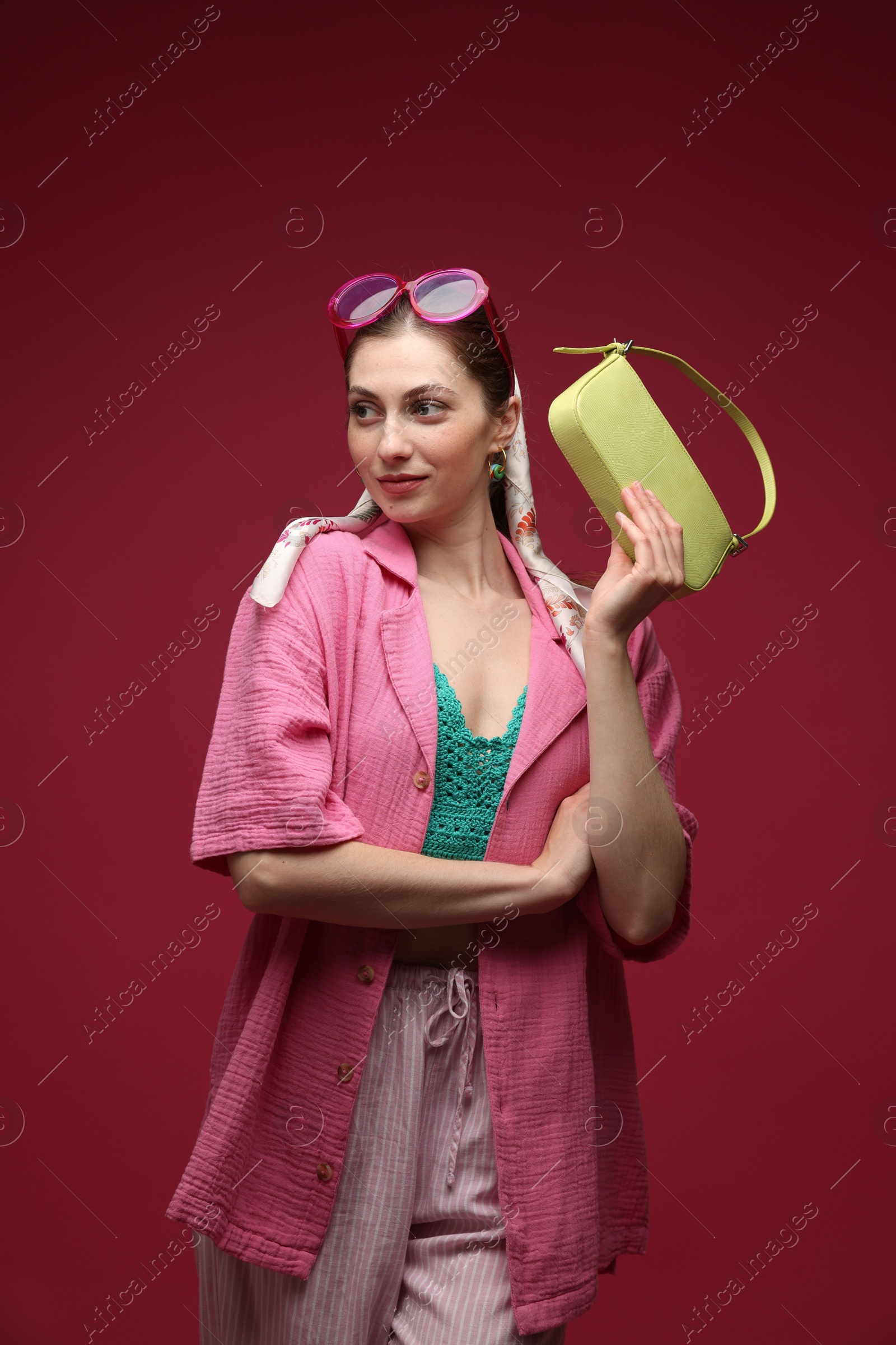Fashionable portrait of beautiful woman in stylish outfit on dark red background Photo of Fashionable portrait of beautiful woman in stylish outfit on dark red background